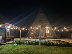 een huis met een piramidevormig dak 's nachts bij Chalé Sossegado in Treviso