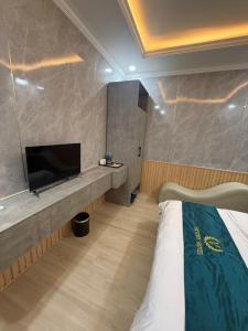 a hotel room with a bed and a flat screen tv at Victory Hotel in Xóm Hương Phùng