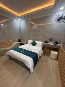 a bedroom with a large bed with a blue blanket at Victory Hotel in Xóm Hương Phùng