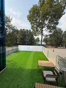 a green field with a bench on a tennis court at Victory Hotel in Xóm Hương Phùng