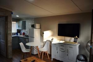 a kitchen with a table and a tv on the wall at 22 Symmonds Studio in Melmoth