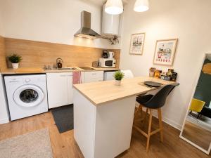 a kitchen with a sink and a washing machine at Appartement calme et spacieux, tout équipé in Saint-Quentin