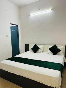 a bedroom with a large bed with black and green pillows at Hotel park view in Bathinda +3 photos