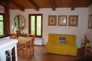 a living room with a table and a yellow couch at Camporegio in Civitella Cesi +46 photos