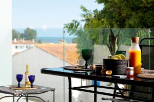 a table on a balcony with wine bottles and glasses at JB RiaMar ll by Meditrust in Alvor