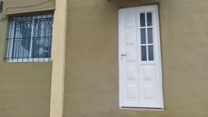 a white door on the side of a building at ruta 8 suites in Santa Catalina