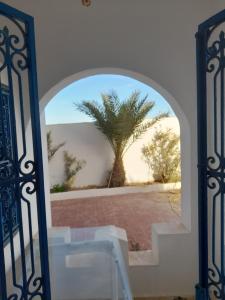 an open gate with a palm tree in the background at Taguermess Tag 2 in Taguermess