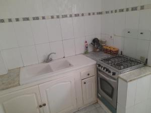 a white kitchen with a stove and a sink at Taguermess Tag 2 in Taguermess