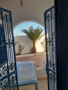 an open door with a table and a palm tree at Taguermess Tag 2 in Taguermess