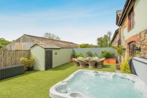 a backyard with a hot tub in the grass at 6 Bed in Holsworthy oc-s41430 in Merryfield