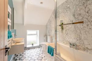 a bathroom with a tub and a sink and a toilet at 6 Bed in Holsworthy oc-s41430 in Merryfield +35 photos
