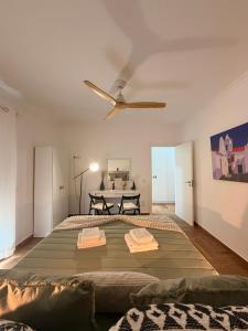 a bedroom with a large bed with a ceiling fan at A Janela do Cantinho in Reguengos de Monsaraz