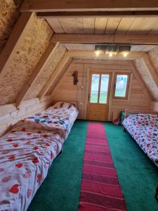 two beds in a room with a red carpet at Auto kamp Runolist in Rožaje