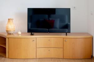 a television on top of a wooden entertainment center at JB RiaMar ll by Meditrust in Alvor