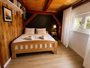 a bedroom with a bed in a wooden house at 4Rest&Fun Krušné hory in Klíny