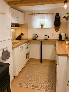 a small kitchen with white cabinets and a table at 4Rest&Fun Krušné hory in Klíny +13 photos