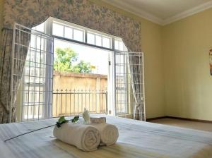 a bedroom with a bed with a large window at Versailles in Pretoria