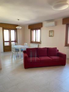 a living room with a red couch and a table at La casa di John in Guglionesi