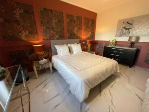 a bedroom with a bed and a wall with paintings at Villa Bois d'Argent in Lagraulière