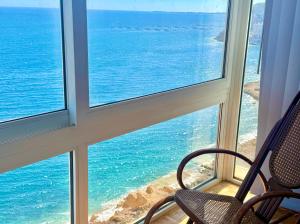 a chair in a room with a view of the ocean at El Barco in Almería
