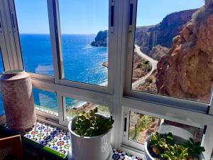 a view of the ocean from a window with plants at El Barco in Almería +48 photos