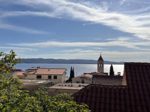 a view of a city with a clock tower and the water at Apartments Šebin in Baška Voda