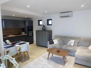 a living room with a couch and a table at Villa Studio Cosy Hauteur Vallauris L'Atelier in Vallauris