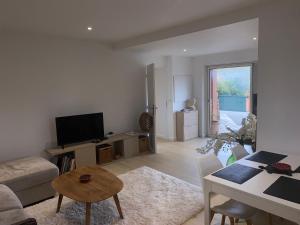 a living room with a couch and a tv and a table at Villa Studio Cosy Hauteur Vallauris L'Atelier in Vallauris
