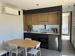 a kitchen with a table and chairs in a kitchen at Tiny House en parcela de Puerto Varas in Puerto Varas
