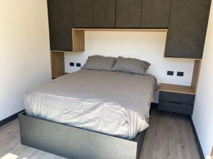 a bedroom with a large bed with brown cabinets at Tiny House en parcela de Puerto Varas in Puerto Varas