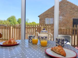 a table with two plates of croissants and orange juice at The Granary in York