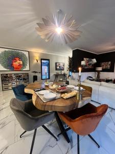 a living room with a table and chairs and a couch at Villa Bois d'Argent in Lagraulière