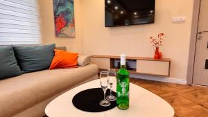 a living room with a bottle and two glasses on a table at Villa ARIA in Trpejca