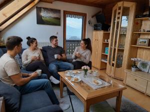 a group of people sitting on a couch in a living room at Appartement Fromme Helene in Millstatt