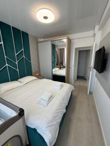 a bedroom with a large bed with two towels on it at TheBlueEscape Apartment in Năvodari