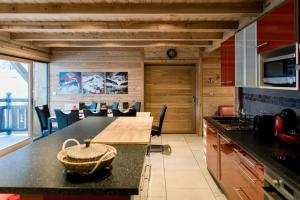 a kitchen with a table with a basket on a counter at CHALET EVEREST Les CHALETS D'HINOUKA SERRE CHEVALIER-CHANTEMERLE 200 m des pistes in Saint-Chaffrey