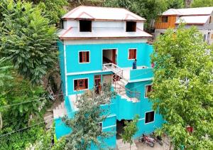 an overhead view of a blue house with trees at The Cozy Cottage in Kundālshai