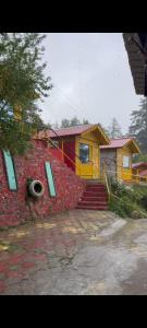 a house with a red brick wall with a tire at Chauhan bambo house in Joshīmath