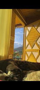 a bedroom with a window with a view of a mountain at Chauhan bambo house in Joshīmath