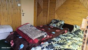 a bedroom with two beds with blankets and pillows at Chauhan bambo house in Joshīmath