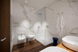a bathroom with a shower and a toilet and a sink at MarePineta Resort in Milano Marittima
