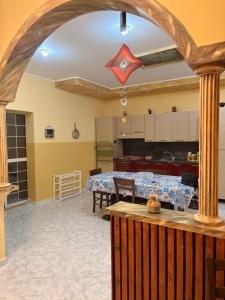 a living room with a table and a kitchen at Casa vacanza da Sandro in Priolo Gargallo
