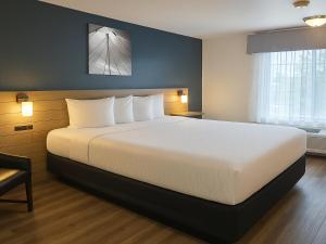 a bedroom with a large bed in a hotel room at Rancho San Diego Inn & Suites in El Cajon