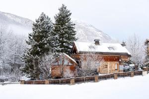 a log cabin in the snow with trees at CHALET EVEREST Les CHALETS D'HINOUKA SERRE CHEVALIER-CHANTEMERLE 200 m des pistes in Saint-Chaffrey