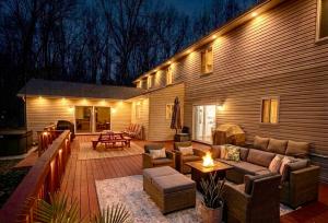 a patio with a couch and chairs and a table at 6BR Luxury Mountain Retreat - Hot Tub, Game Room, Lake, Beach, Karaoke, Bar, Poconos in Albrightsville