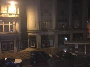 dos autos estacionados frente a un edificio por la noche en ML Lodge, en Cardiff