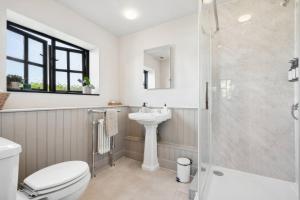 a bathroom with a shower and a toilet and a sink at Five Acres Cottage in Rickmansworth +23 photos