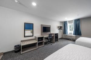 a hotel room with a bed and a desk at Hummingbird Hotel in Goodlettsville