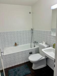 a bathroom with a toilet and a tub and a sink at Studio chic et élégant avec Wi-Fi et Smart TV in Lausanne