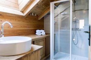 a bathroom with a shower and a white sink at CHALET EVEREST Les CHALETS D'HINOUKA SERRE CHEVALIER-CHANTEMERLE 200 m des pistes in Saint-Chaffrey +18 photos